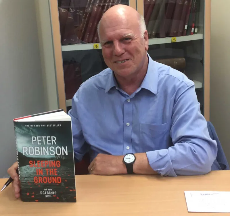 Image: Photograph of Peter Robinson presenting his book <em>Sleeping in the Ground</em>